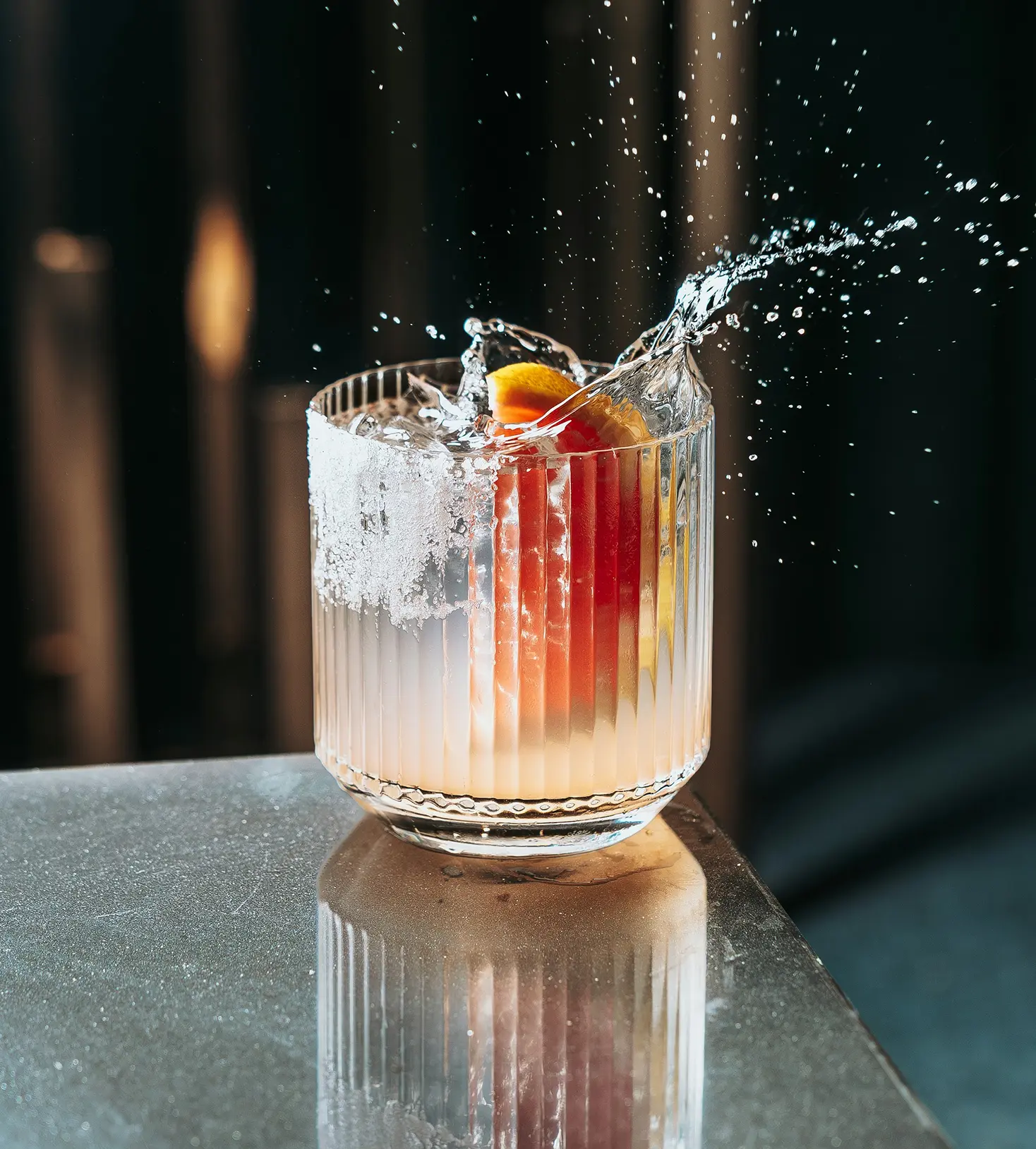 Cocktail con schizzo d'acqua e bordo salato ripreso in movimento.
